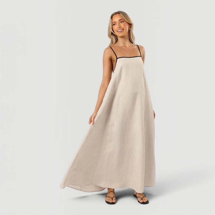 Flowy white sleeveless midi dress for women, ideal for elegant casual summer wear. Features an a-line silhouette.