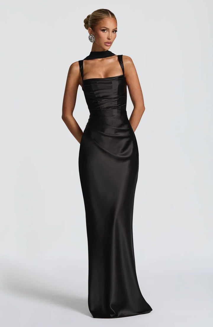 Women's elegant black maxi dress featuring a flattering ruched waist & adjustable spaghetti straps for summer.