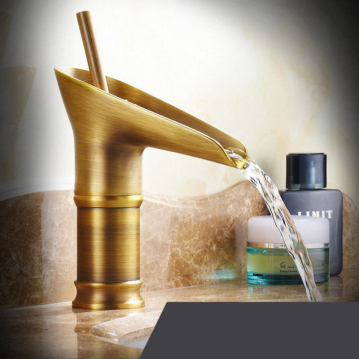 Gold waterfall basin tap, luxurious deck-mounted mixer for modern bathrooms.
