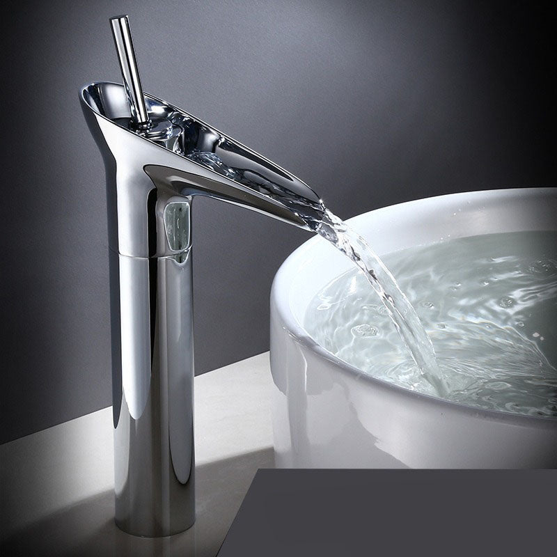 Contemporary waterfall sink faucet, elegant brass design, bathroom decor.
