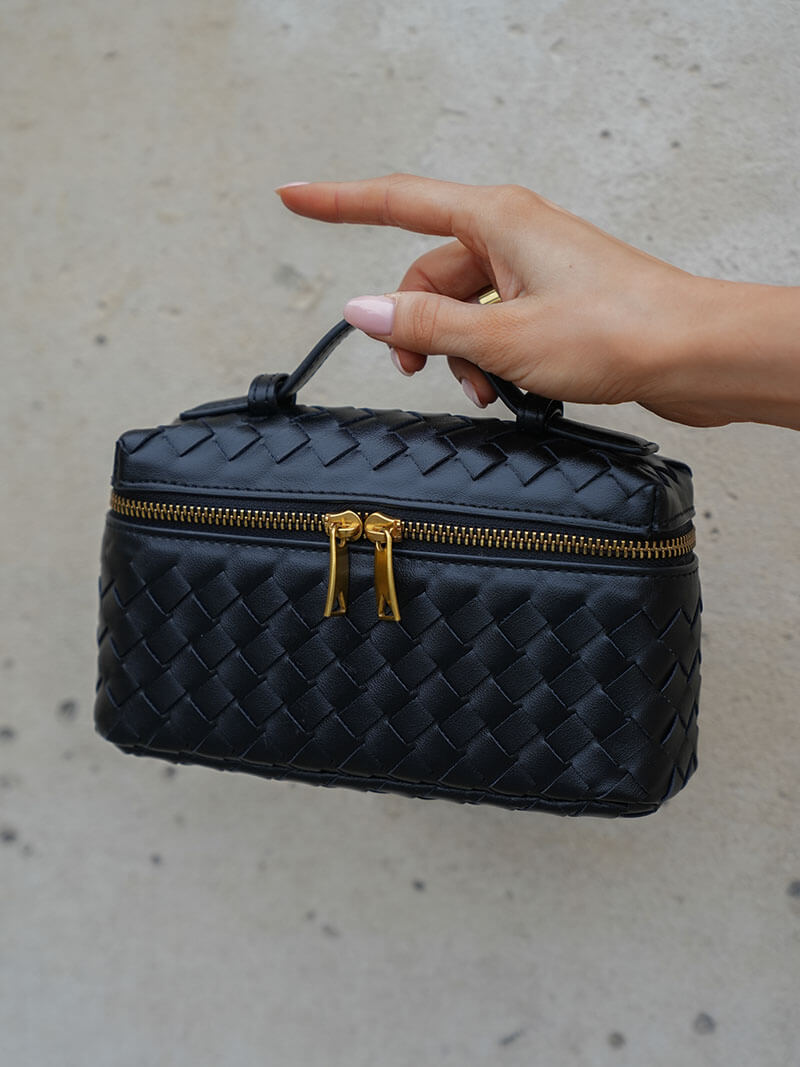 Close-up of a women's elegant shoulder bag, highlighting its beautiful woven texture & compact design.