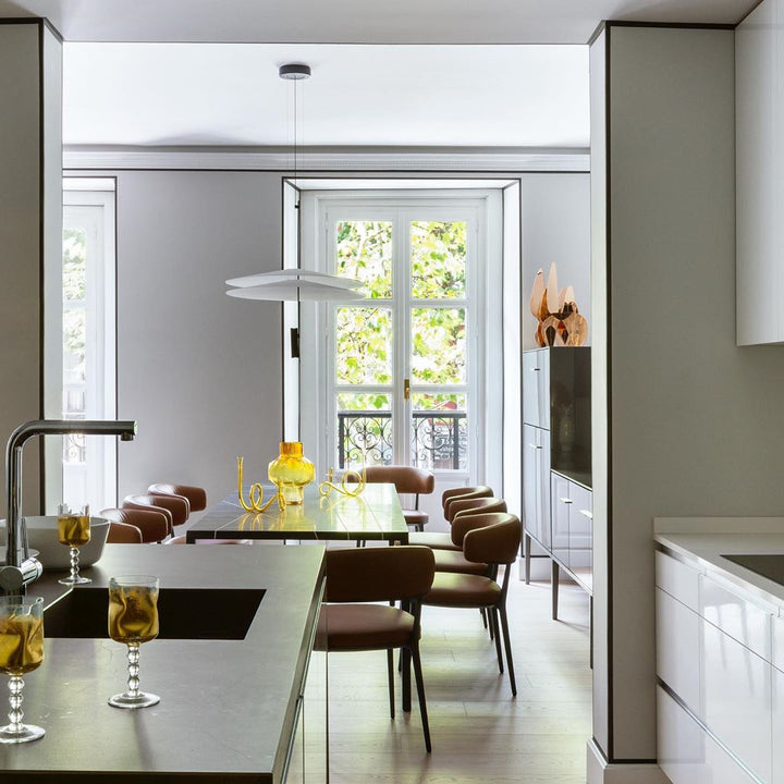Modern integrated LED disc pendant, gold accent, elegant ambient lighting.
