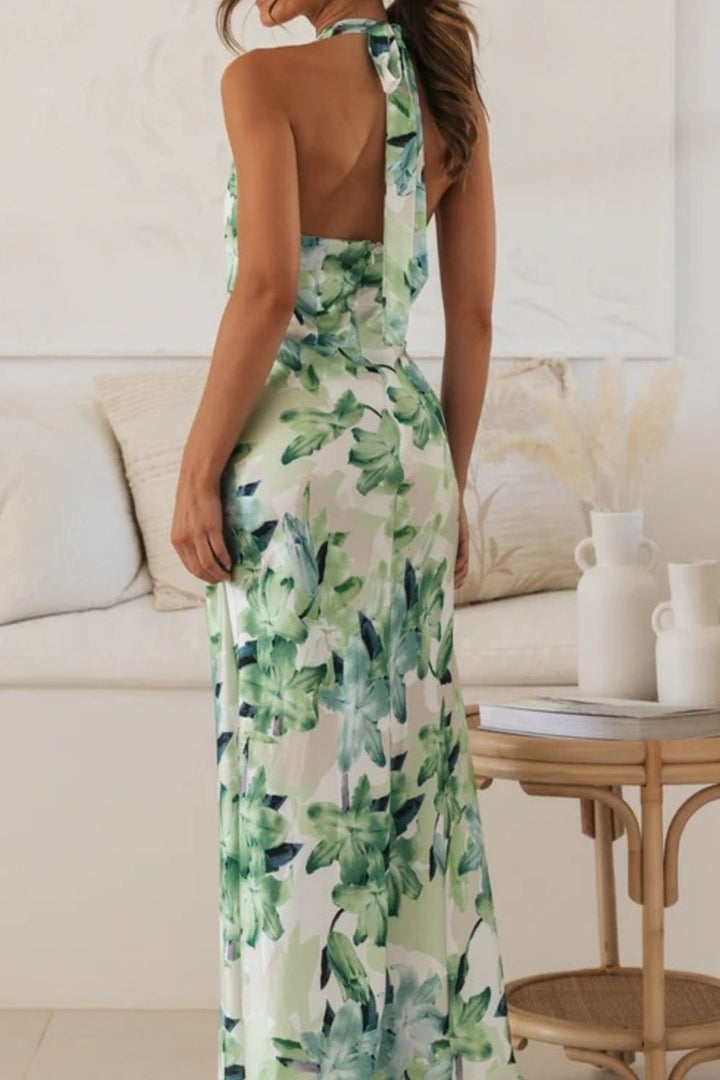 Chic halter neck dress with a beautiful floral pattern and a dramatic side slit, for wedding guests.