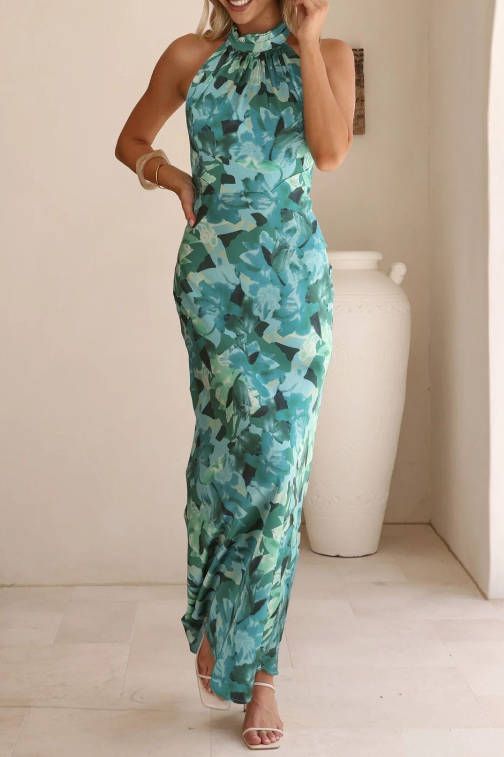 Formal halter neck dress adorned with a floral print and a stylish, flattering slit.