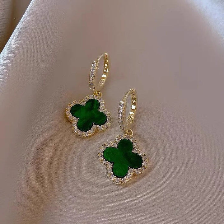 Elegant gold-plated women's clover leaf earrings with sparkling crystals. Timeless lucky charm jewelry.