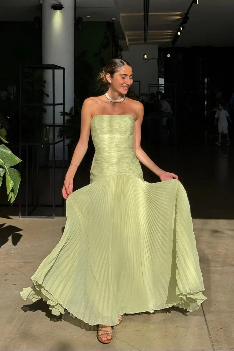 Beautiful green strapless maxi dress for women, featuring elegant pleats, perfect for evening wear.
