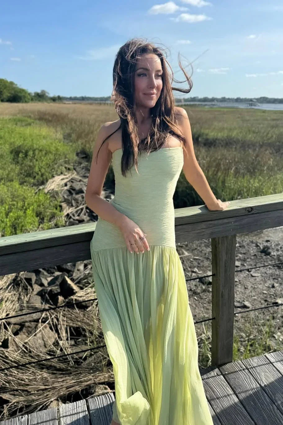 Women's elegant green strapless pleated maxi wedding guest dress, suitable for formal events.