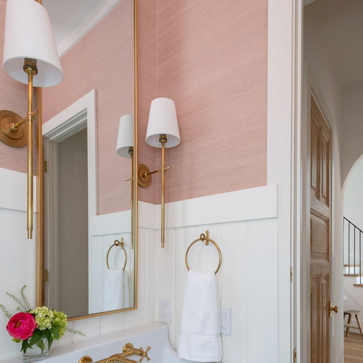 Chic wall sconce with a soft fabric shade, providing ambient light in a metal frame.