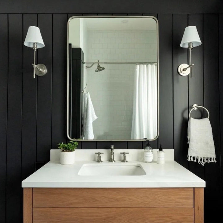 Matte black wall sconce with a cream fabric shade, perfect for bedroom lighting.