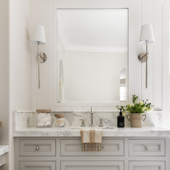 Hardwired wall sconce with a soft fabric shade, durable metal construction for indoor use.