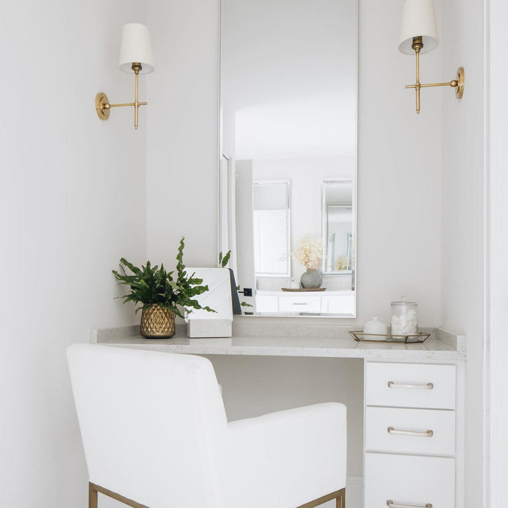 Sleek metal wall sconce with a diffused fabric shade for gentle room illumination.
