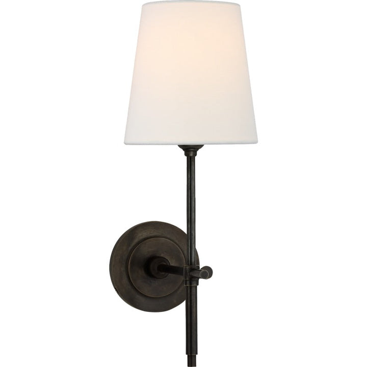 Wall lamp with soft cream fabric shade and sturdy metal arm, perfect for bedside.
