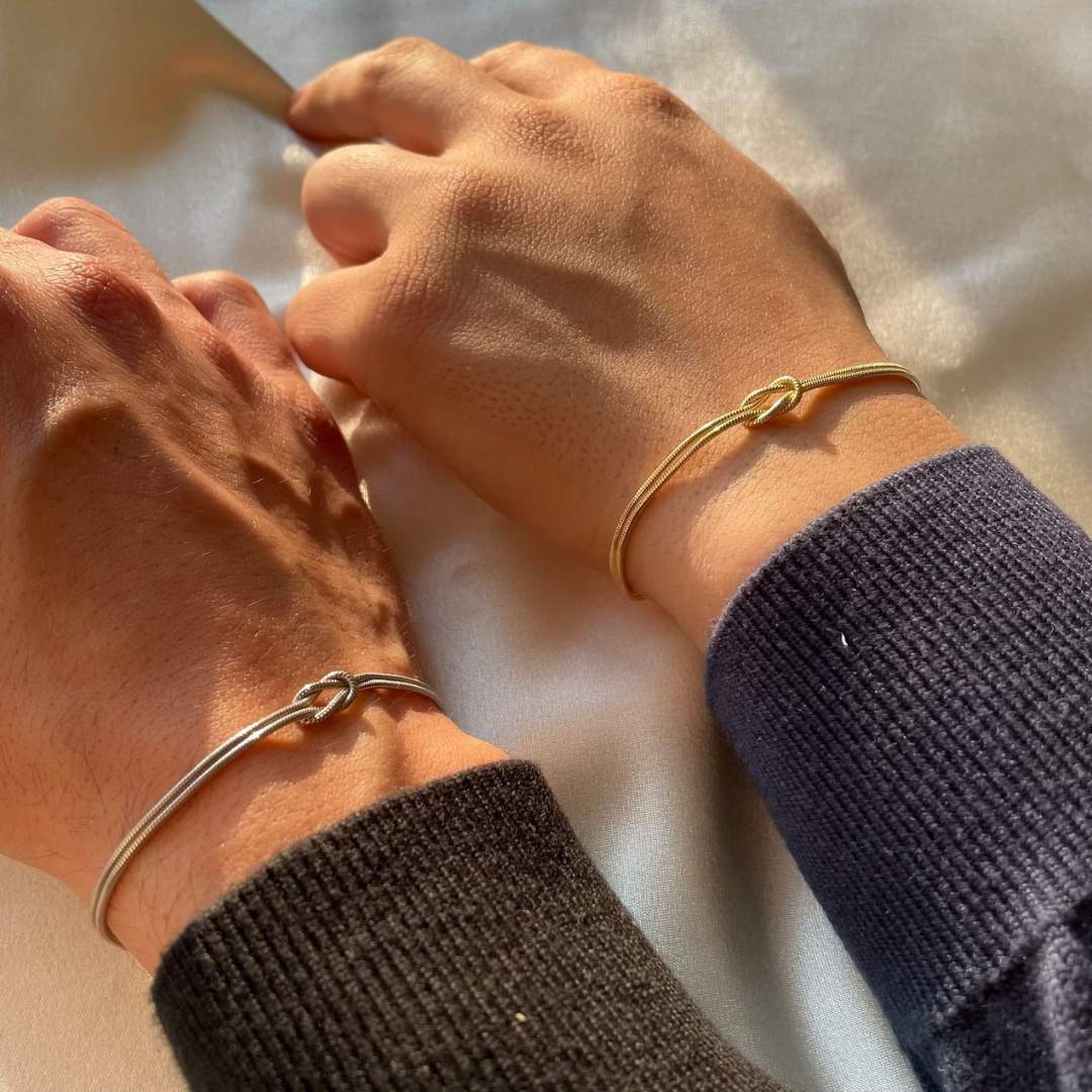 Close-up of elegant knot bracelet, subtle stainless steel women's jewelry, perfect for daily wear.