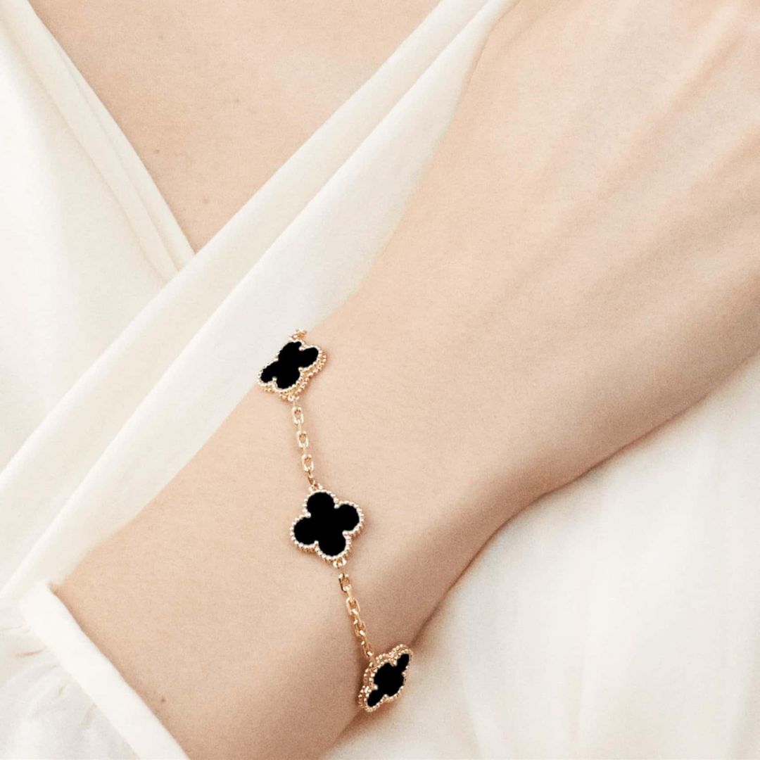 Dainty silver tone clover charm bracelet with colorful agate, an elegant women's accessory.