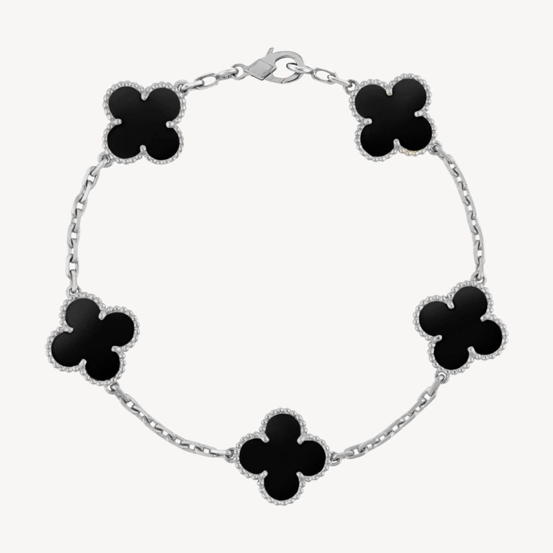 Close-up of an elegant clover charm bracelet showcasing intricate agate and delicate design.