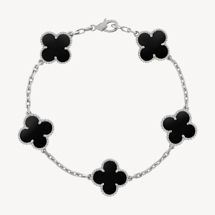 Close-up of an elegant clover charm bracelet showcasing intricate agate and delicate design.