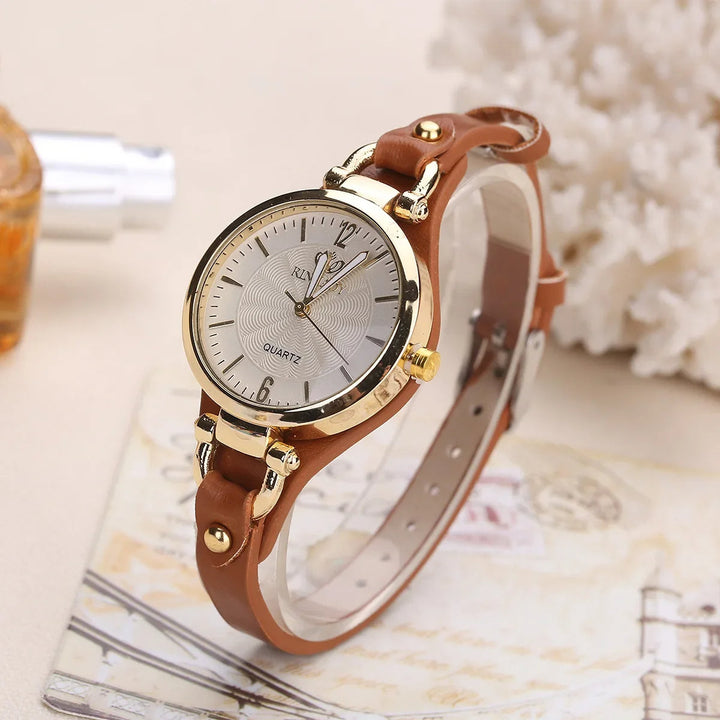 Elegant ladies' quartz watch with intricate engraved dial and smooth vegan leather strap.