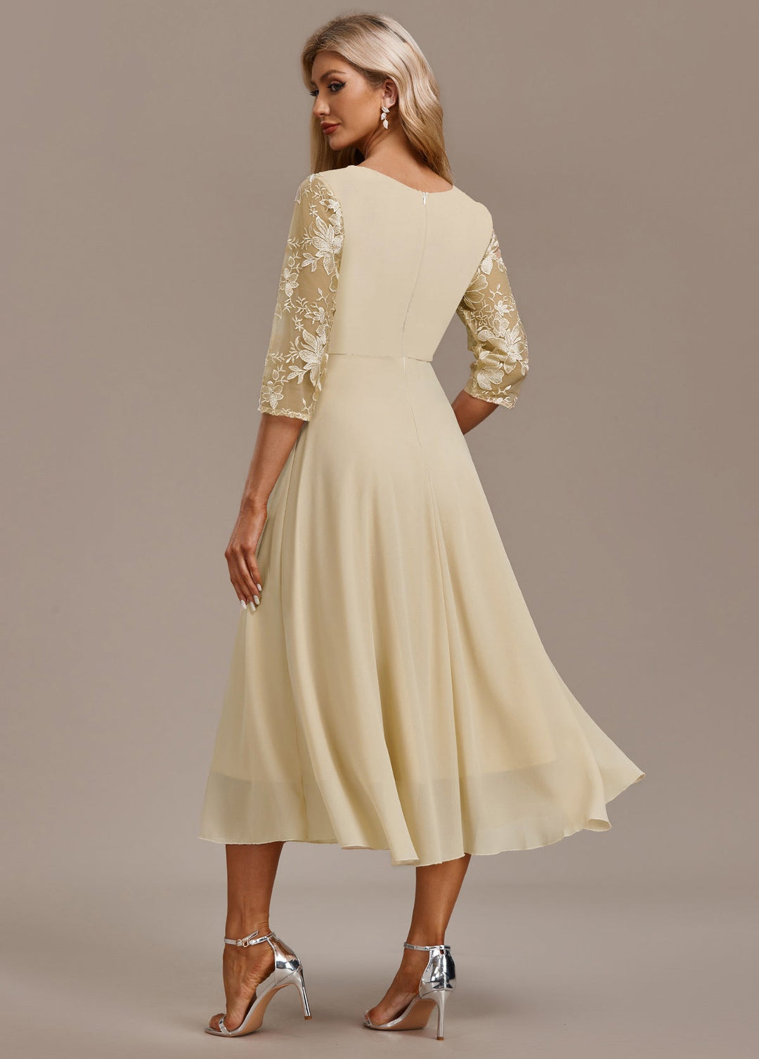 Women's elegant light yellow midi dress with intricate embroidery, round neck, and 3/4 sleeves; ideal for occasions.