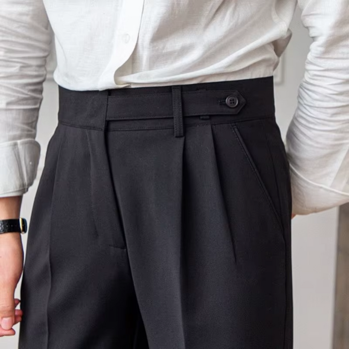 Man wearing elegant pleated dress trousers, showcasing their modern fit for formal events.