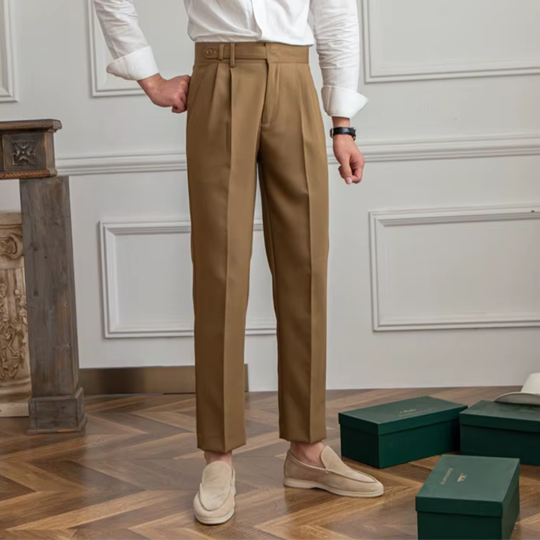 Flat lay of sophisticated men's pleated chino trousers, ready for modern elegant styling.