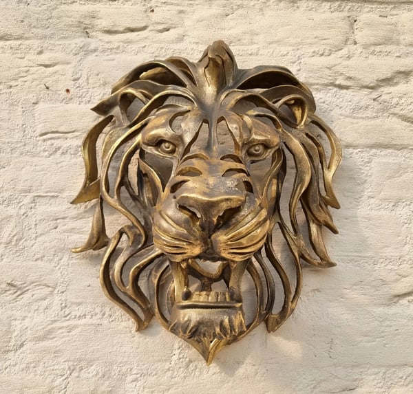 Close-up of a detailed metal lion head wall art, showcasing intricate craftsmanship.