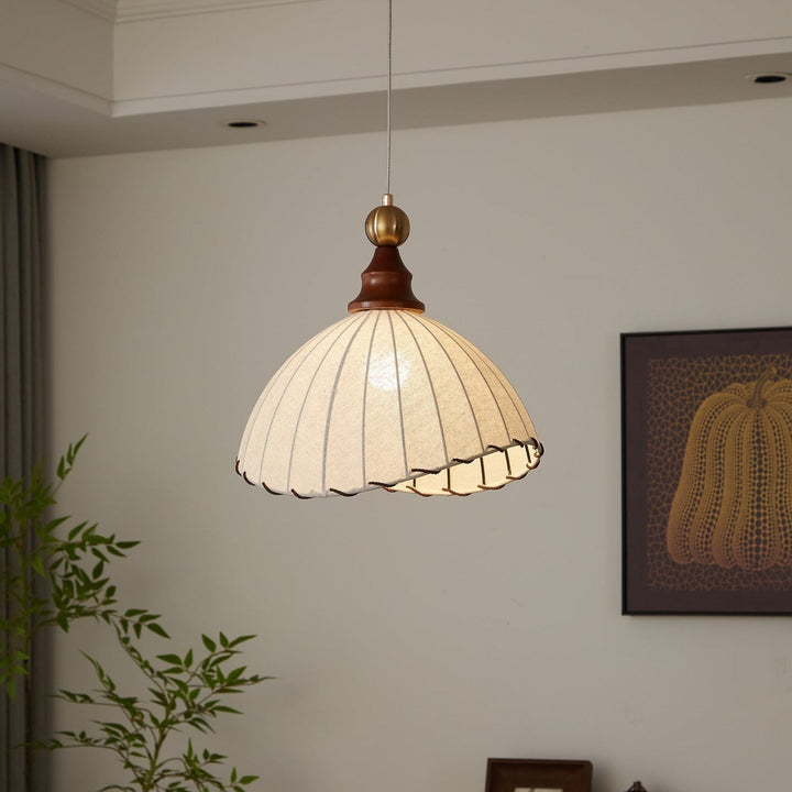 Elegant modern pendant light with fabric shade, gold accent & wood details for stylish home decor.