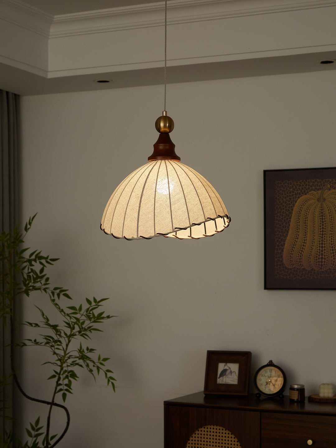 Elegant pendant light, fabric shade, gold accent, wood details for contemporary interior design.