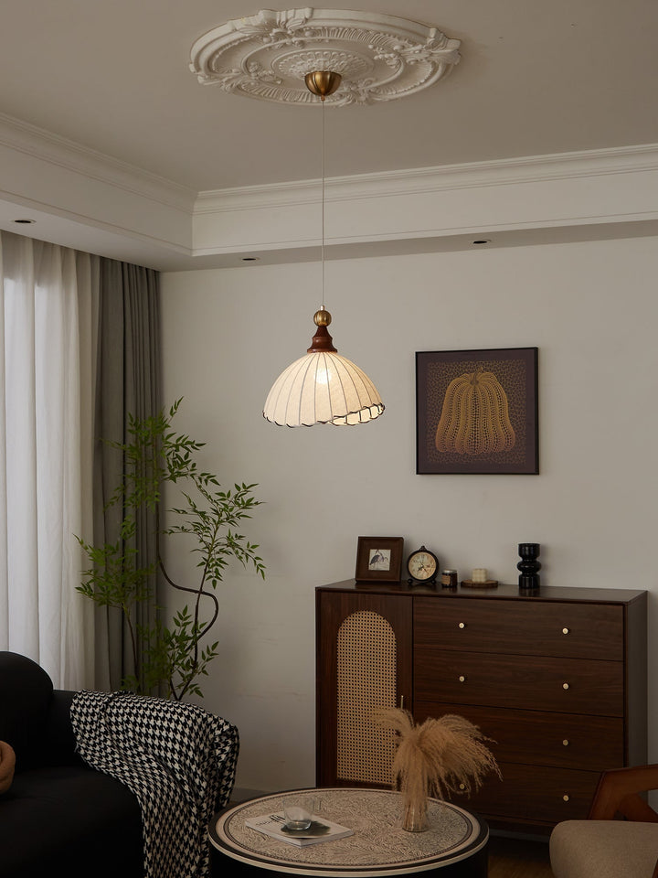 Beautiful modern pendant lamp with a soft fabric shade, luxurious gold, and natural wood.