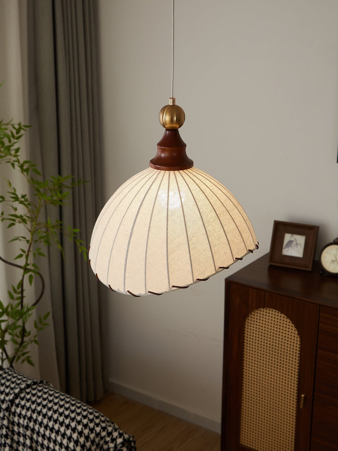 Modern home decor pendant light, fabric shade, gold, and wood details, creating a warm ambiance.