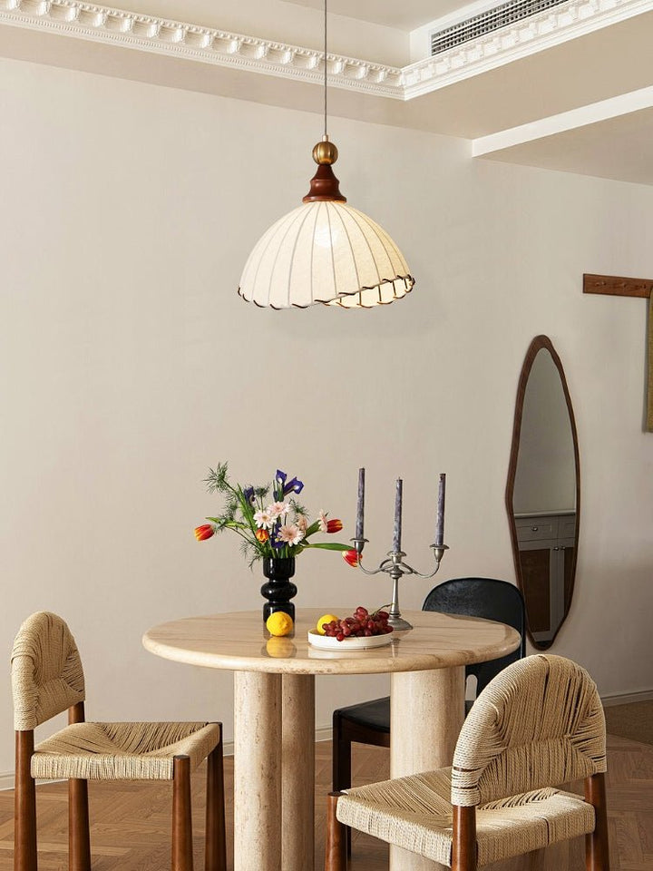Stylish interior lighting: an adjustable pendant lamp with fabric, gold, and wood for a modern touch.
