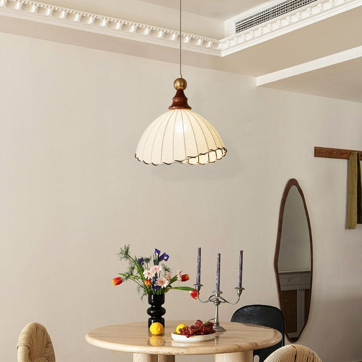 Stylish interior lighting: a modern pendant lamp with a fabric shade, gold & wood elements.