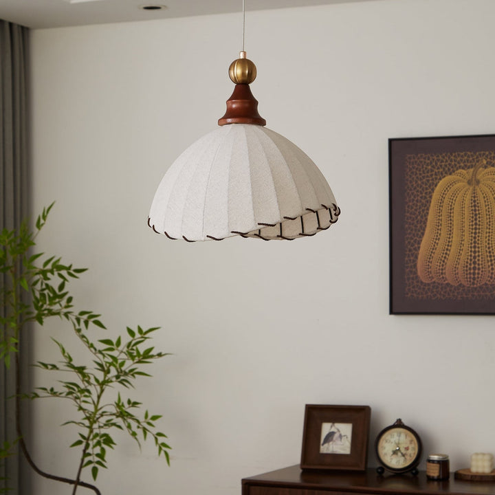Timeless modern pendant light with a graceful fabric shade, gold trim, and wooden elements.