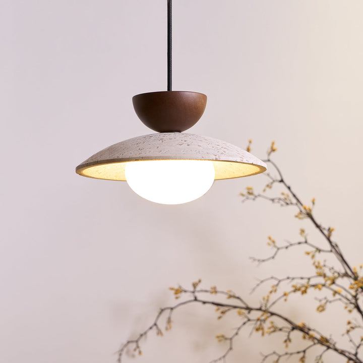 Modern pendant light with a sculptural design, combining wood, travertine, and glass for upscale home decor.