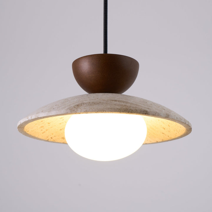 Close-up: Textured travertine stone and smooth wood details of a modern pendant light.