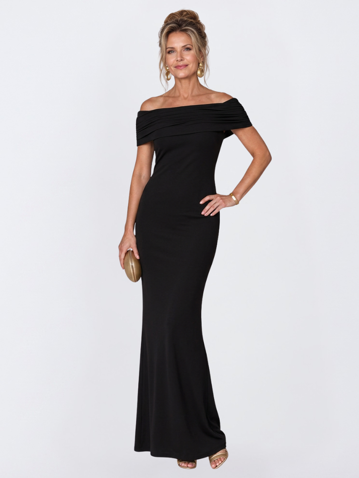 Close-up of the elegant twist-back design on a burgundy off-shoulder bodycon maxi dress, occasion wear.