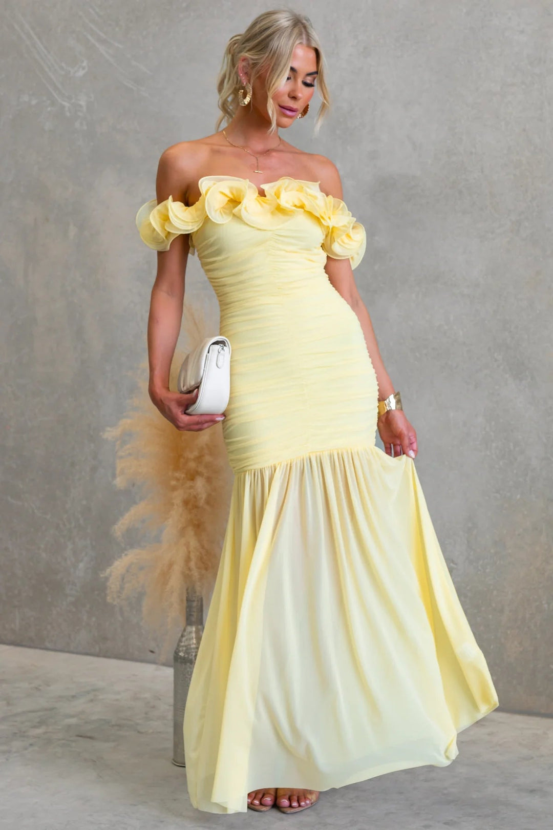 Pleated off-shoulder maxi dress with delicate ruffles; a stylish & formal option for wedding guest attire.