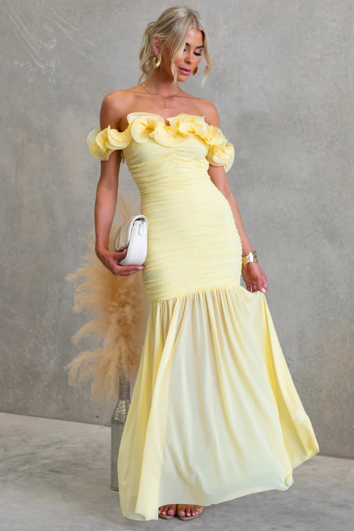 Pleated off-shoulder maxi dress with delicate ruffles; a stylish & formal option for wedding guest attire.
