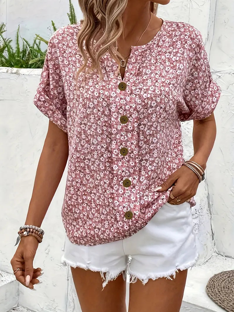 Feminine pink floral blouse with short sleeves and button-down front, great for elegant summer style.