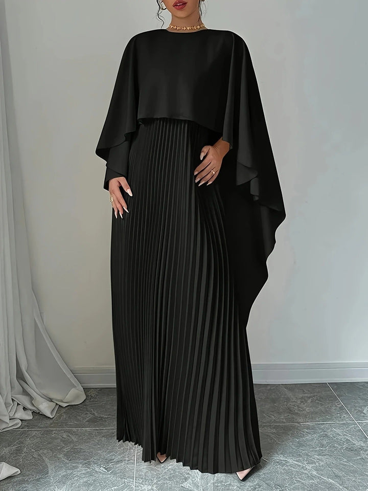 Detailed view of elegant pleats on a women's formal cape maxi dress, perfect for wedding guest attire.