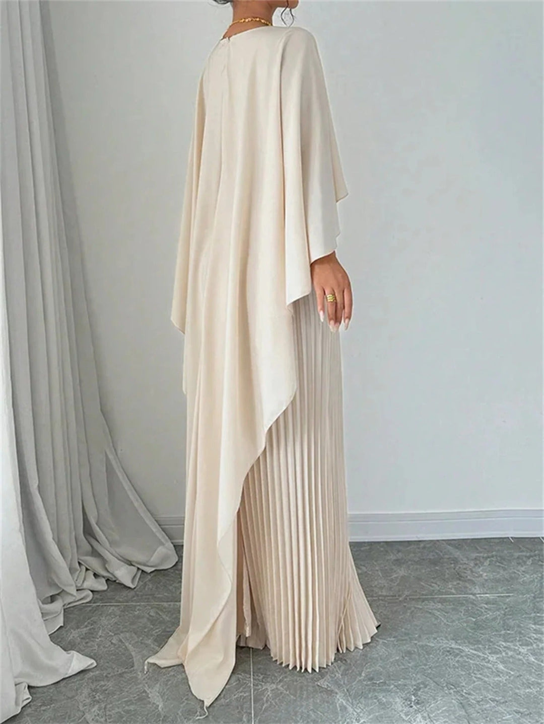 Beautifully pleated bodice & flowing cape on a women's maxi dress, suitable for wedding guests.