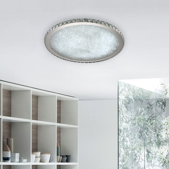 Modern flush mount LED ceiling light with sparkling crystal details. Round design brightens bedrooms & living rooms.