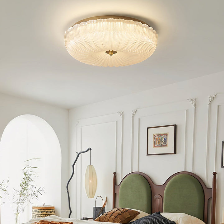 Sleek round flush mount ceiling light with unique rippled glass for diffuse LED lighting.