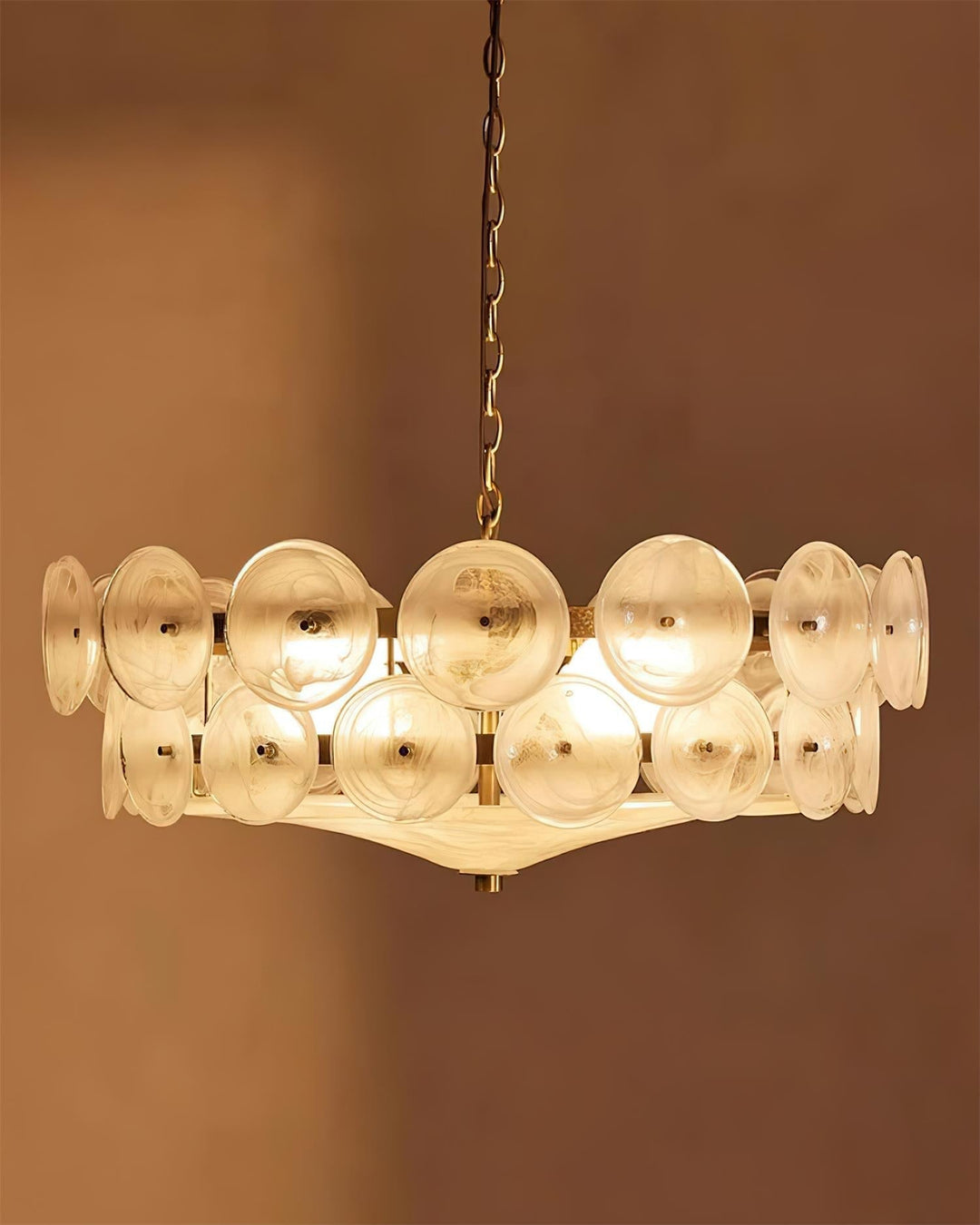 Round glass and metal chandelier installed in a bright, elegant interior.