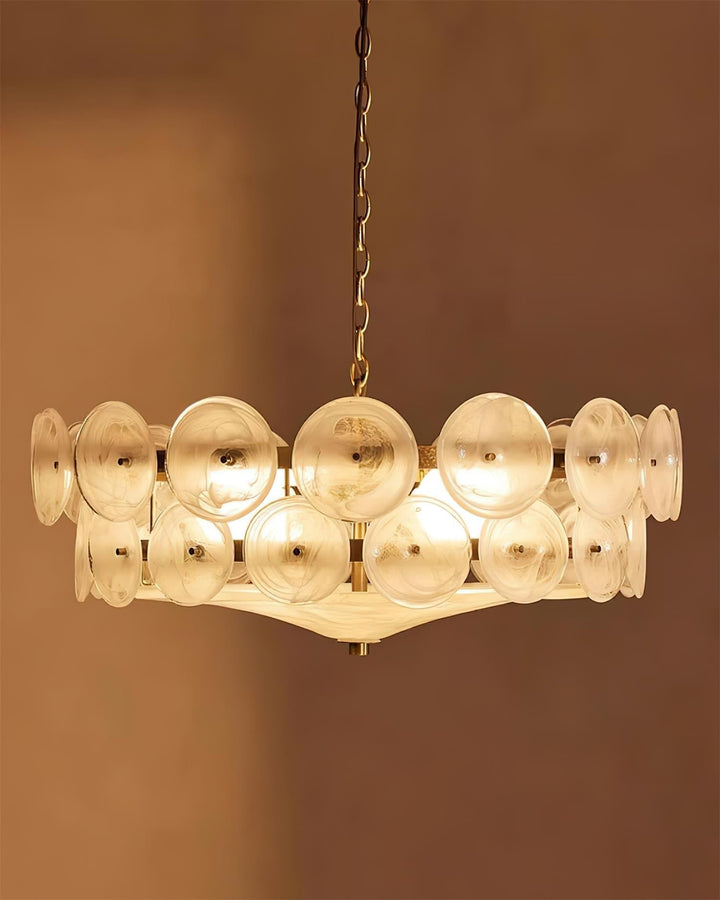Round glass and metal chandelier installed in a bright, elegant interior.