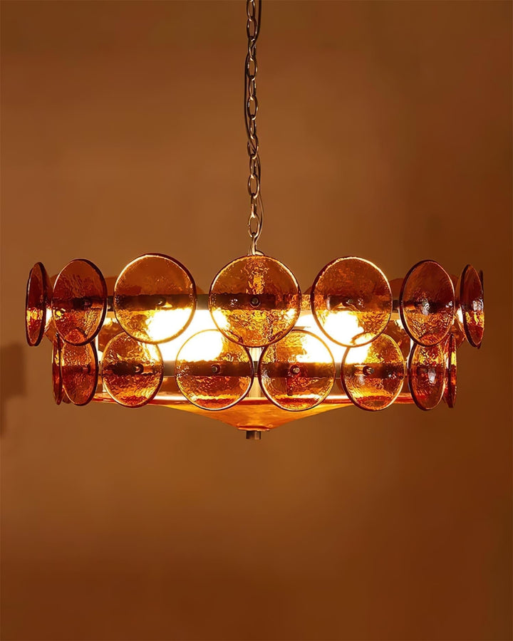 Polished metal frame supporting round glass shades on an elegant chandelier.