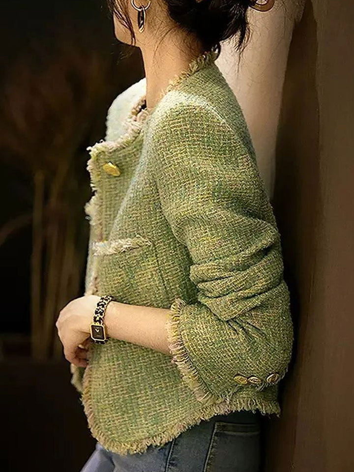 Close-up of a women's black tweed jacket featuring a classic round neckline.