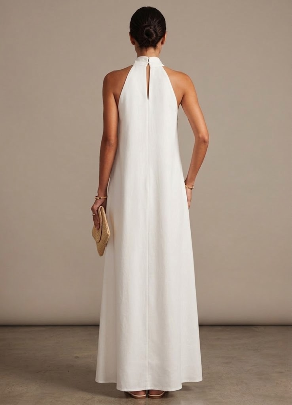 Women's white halter neck maxi dress with an elegant, flowing design, suitable for occasion wear or summer parties.