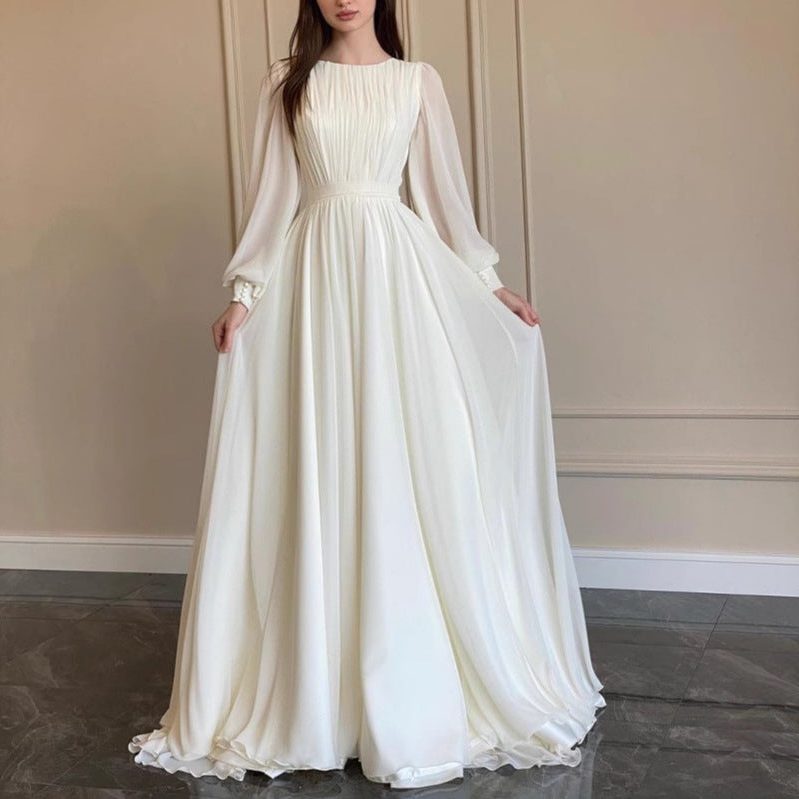Elegant white long sleeve maxi dress for women, perfect for wedding guests. Formal occasion wear with a flowing silhouette.