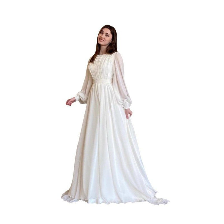 Graceful women's white long sleeve maxi dress, an elegant formal evening gown with flowing fabric for wedding guests.