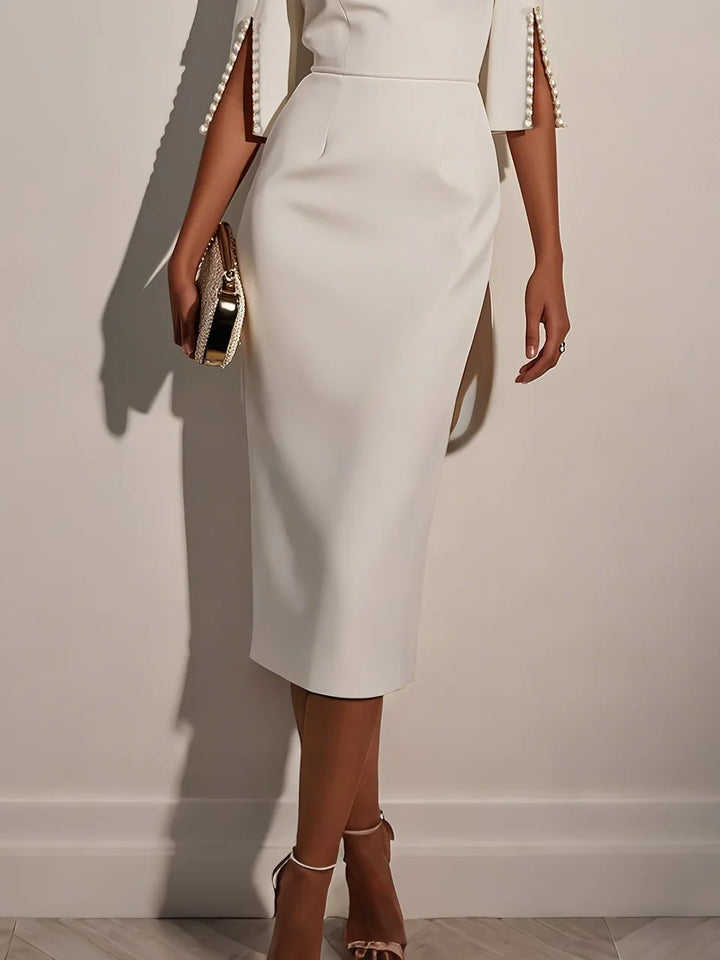 Formal white cocktail dress featuring elegant pearl embellishments.